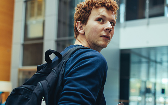 Student heading to class with a backpack on.